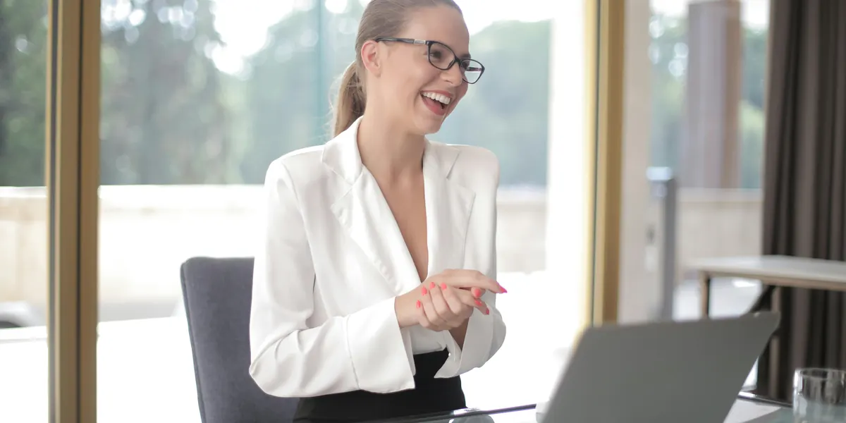 Smiling businesswoman in glasses working at a desk with a laptop