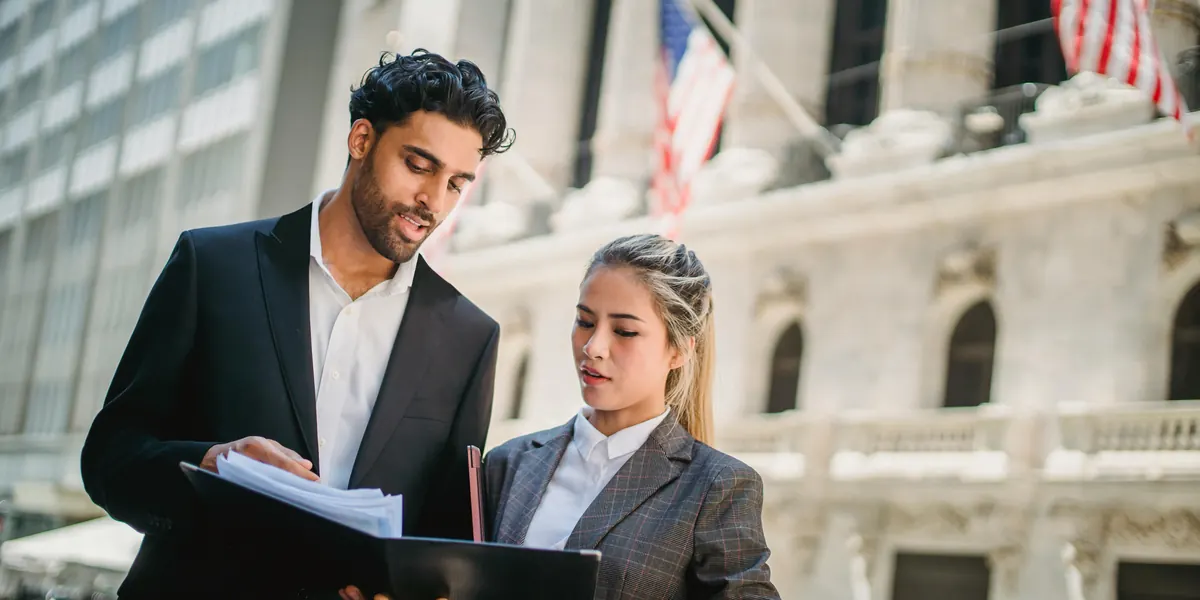 Two business partners reviewing a folder outdoors