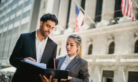 Two business partners reviewing a folder outdoors