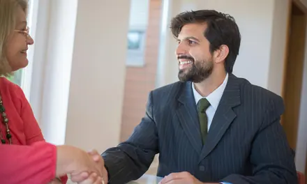 Smiling businessman in a suit shaking hands with a client