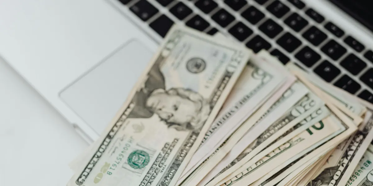 U.S. dollar bills lying on a laptop keyboard