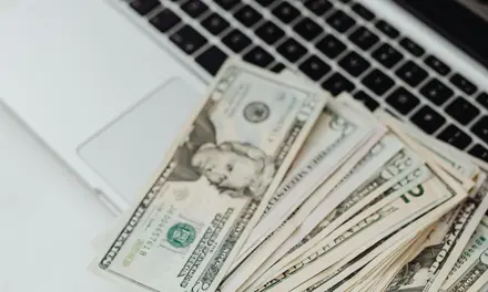 U.S. dollar bills lying on a laptop keyboard